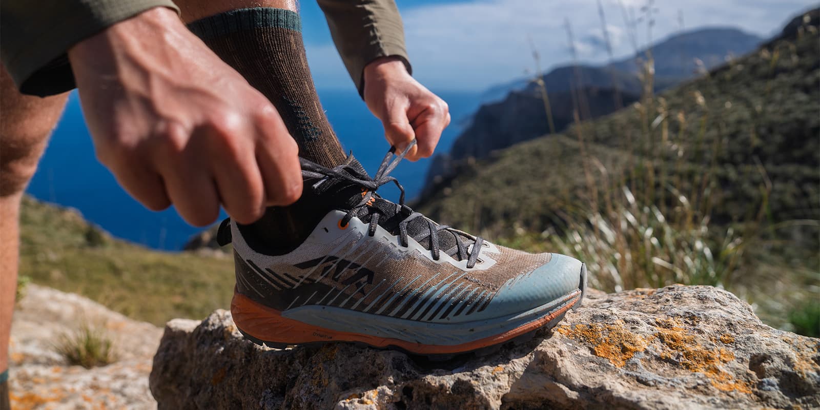 person tying his lowa shoes