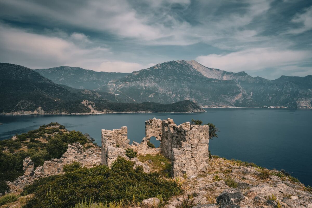 Old ruin on top of hill with body of water in the background